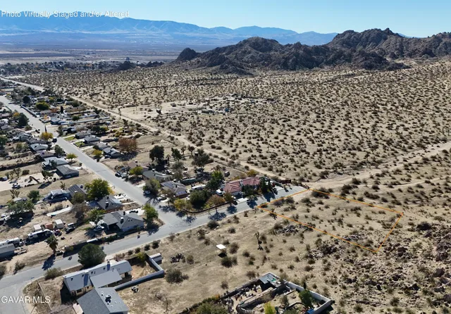 an aerial view of residential house with yard and mountain view in back