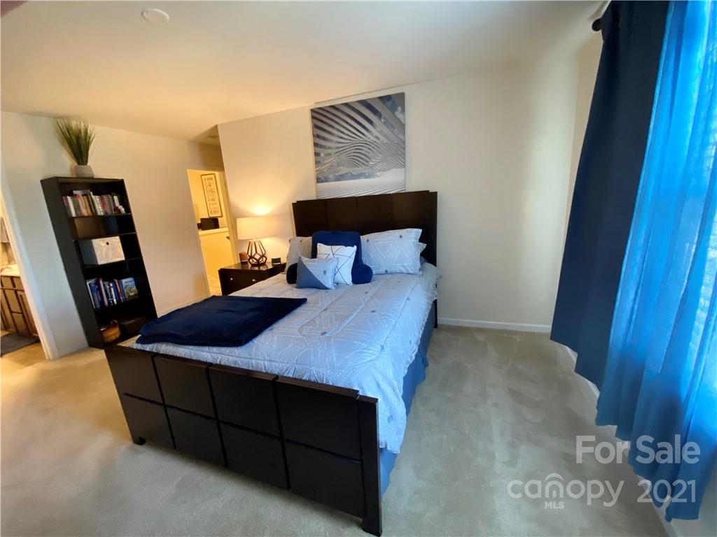 6339 Prosperity Church Road Charlotte, NC 28269 - Photo 13 of 21 a bed sitting in a bedroom next to a cabinet