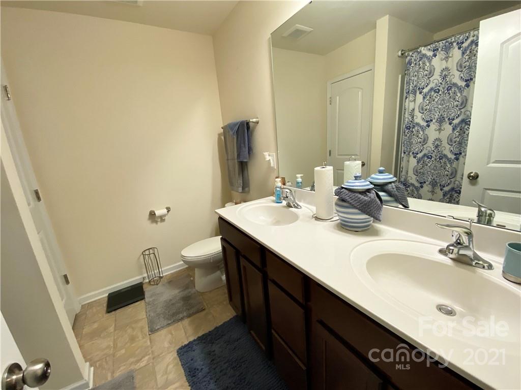 6339 Prosperity Church Road Charlotte, NC 28269 - Photo 14 of 21 a bathroom with a granite countertop sink and a mirror