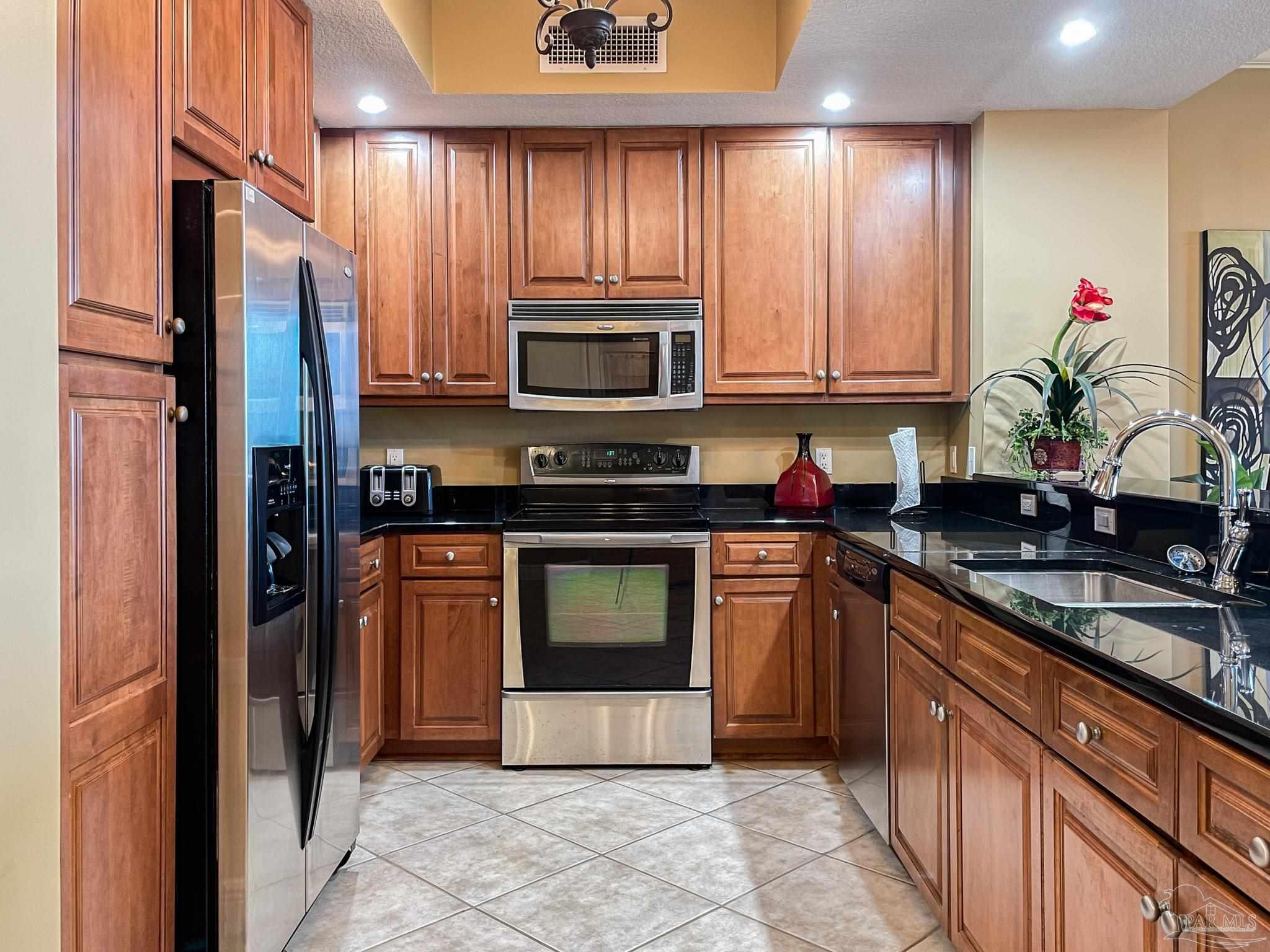 608 Lost Key Drive, Unit 604C Perdido Key, FL 32507 - Photo 2 of 38 a kitchen with granite countertop a refrigerator stove and sink