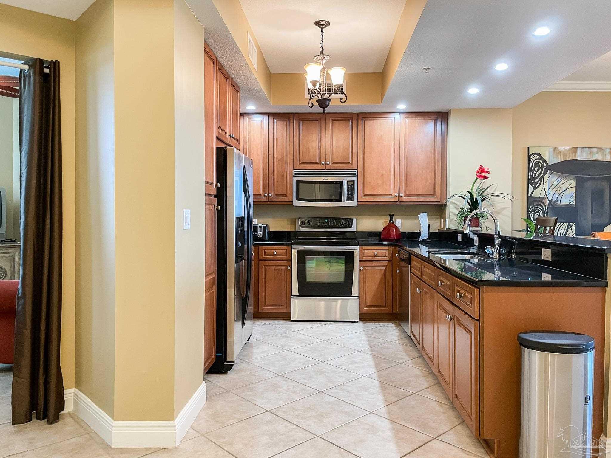 608 Lost Key Drive, Unit 604C Perdido Key, FL 32507 - Photo 26 of 38 a kitchen with stainless steel appliances granite countertop a stove a sink and a refrigerator