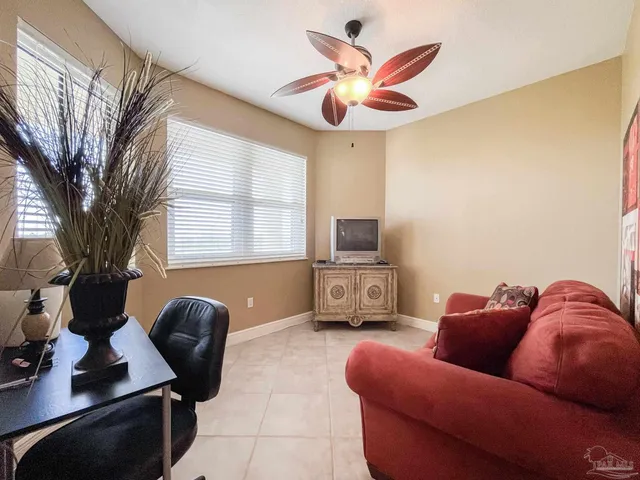 a living room with furniture a flat screen tv and a large window