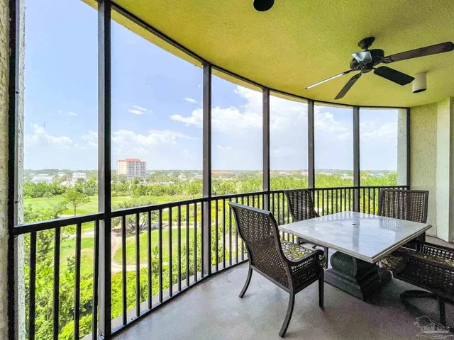 a view of a balcony with furniture and a yard