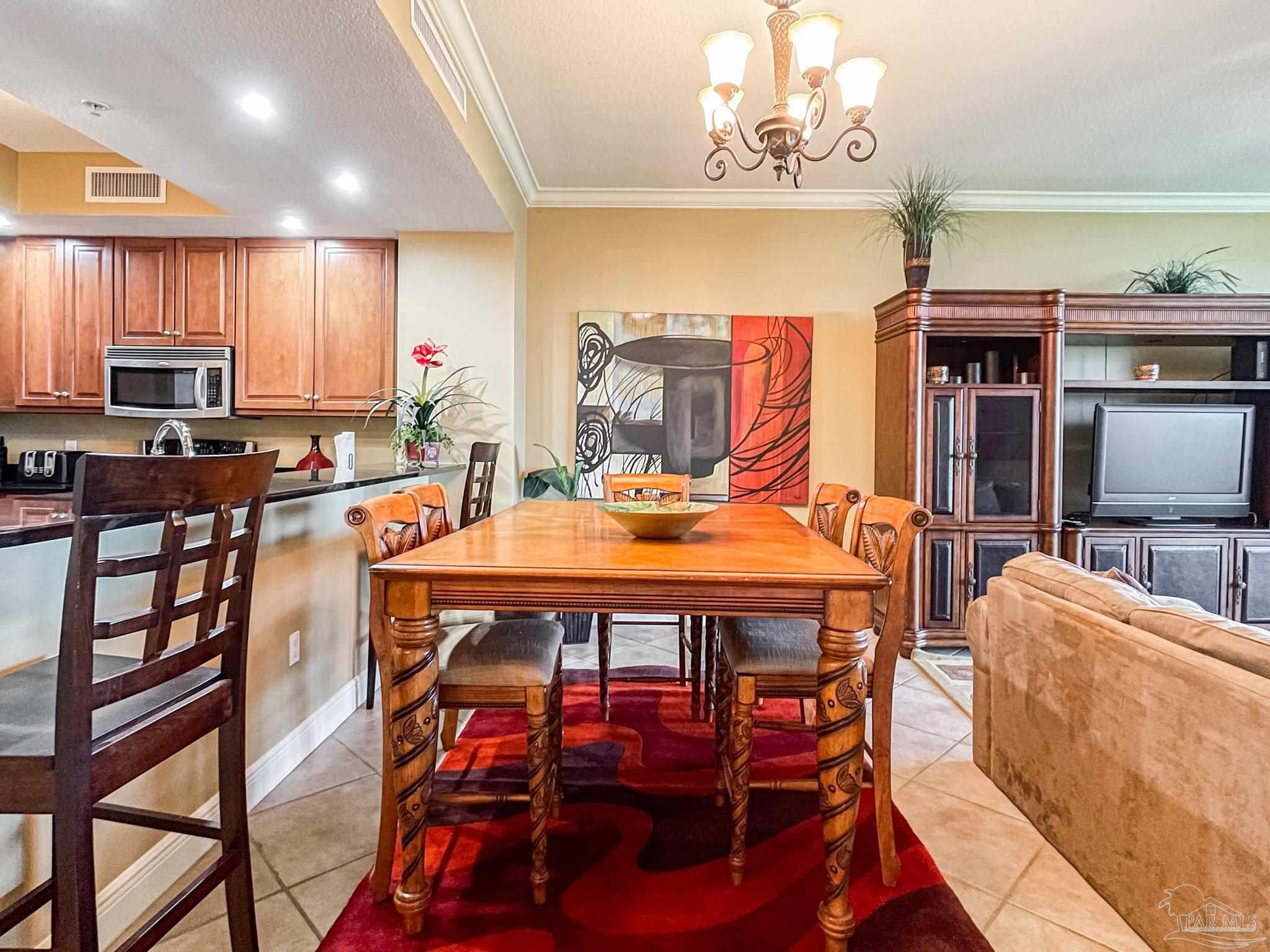608 Lost Key Drive, Unit 604C Perdido Key, FL 32507 - Photo 5 of 38 a dining room with furniture a rug and a chandelier