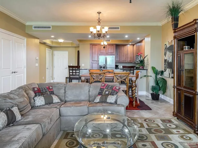 a living room with furniture a dining table and a chandelier