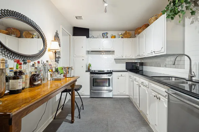 a kitchen with stainless steel appliances granite countertop a stove a sink and a white refrigerator