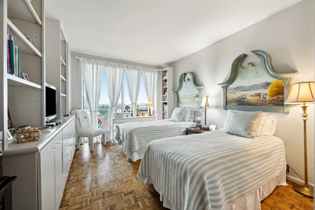 a bedroom with bed and a flat tv screen on the dresser