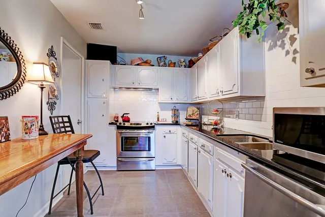 a kitchen with stainless steel appliances a stove a sink dishwasher and a refrigerator