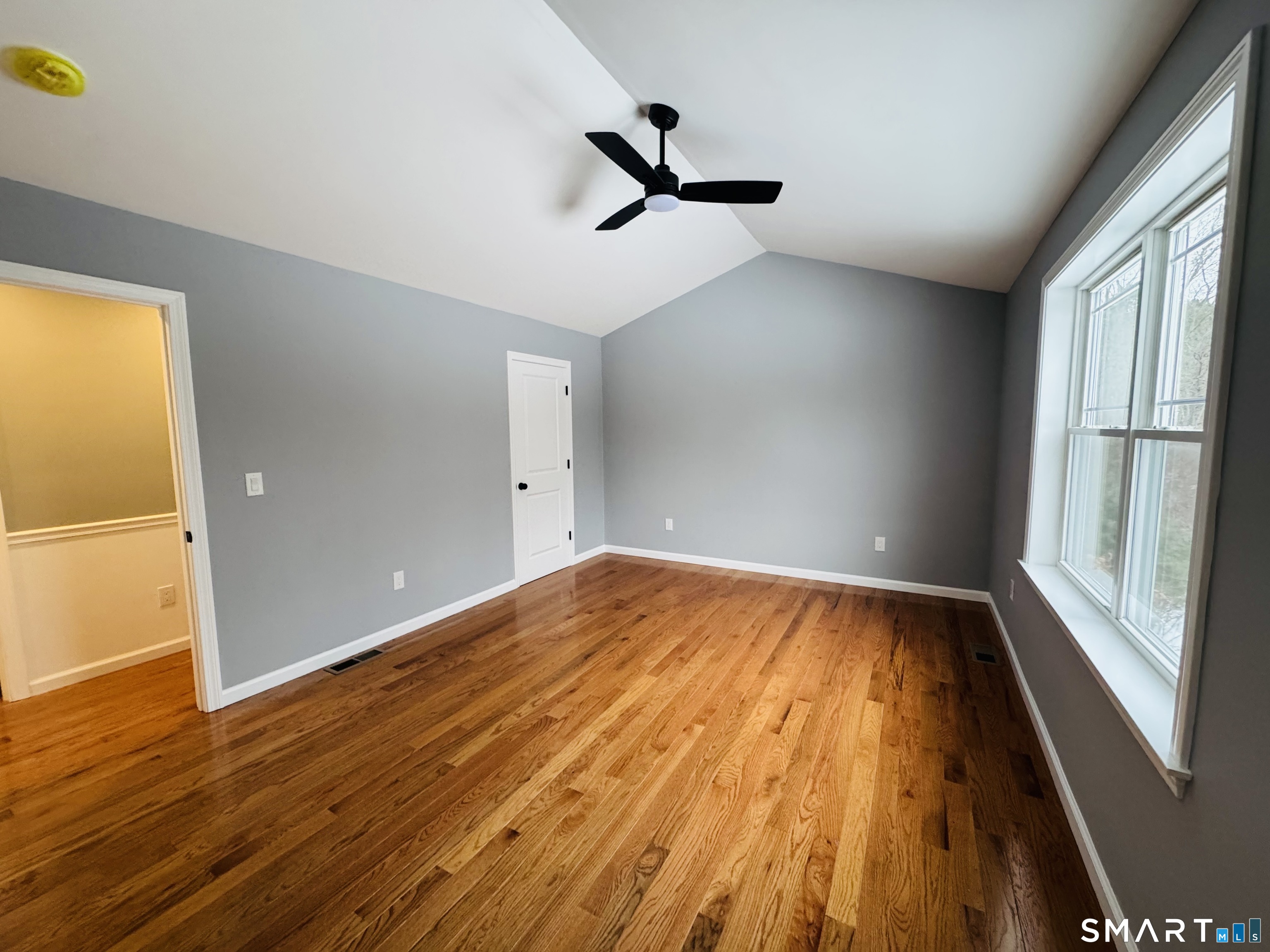 890 Brook Road Scotland, CT 06264 - Photo 5 of 23 an empty room with wooden floor and windows