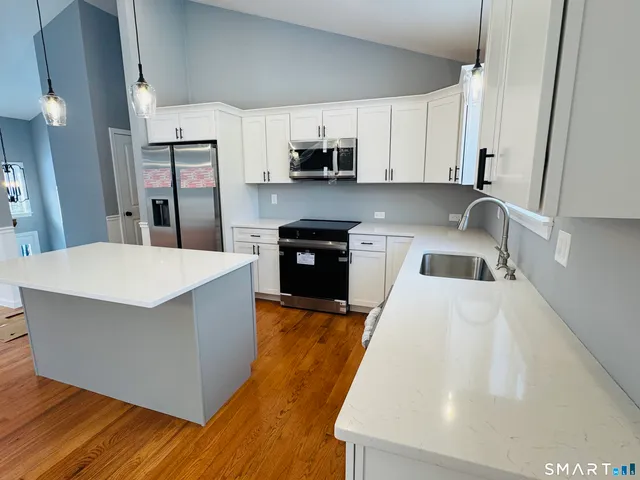 a view of empty room with wooden floor and window