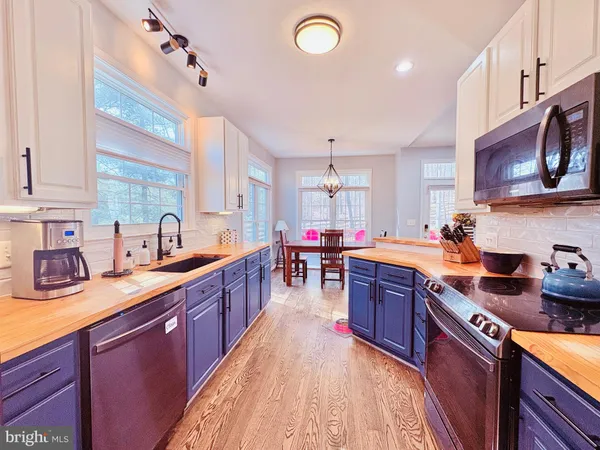 a kitchen with stainless steel appliances granite countertop sink stove top oven and cabinets