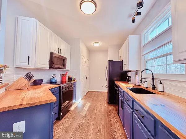 a kitchen with granite countertop a sink stove top oven and cabinets