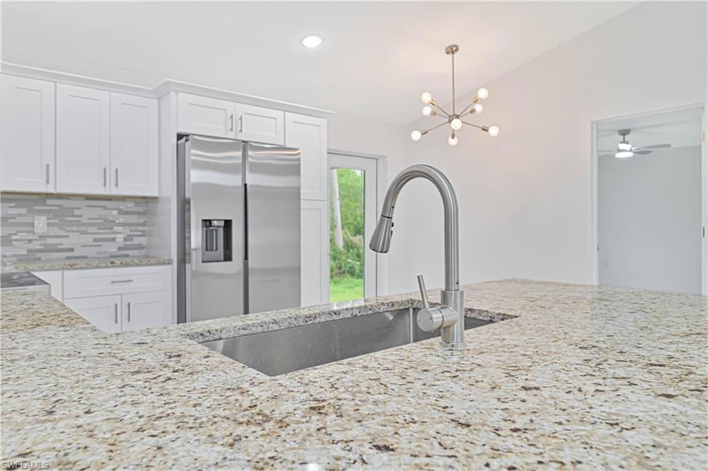 640 Lydia Street Lehigh Acres, FL 33974 - Photo 11 of 26 a view of a kitchen with a faucet a refrigerator and a sink