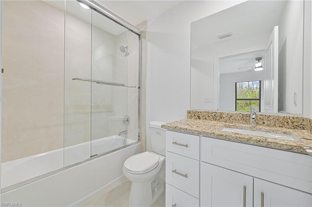 640 Lydia Street Lehigh Acres, FL 33974 - Photo 21 of 26 a bathroom with a granite countertop sink toilet and shower