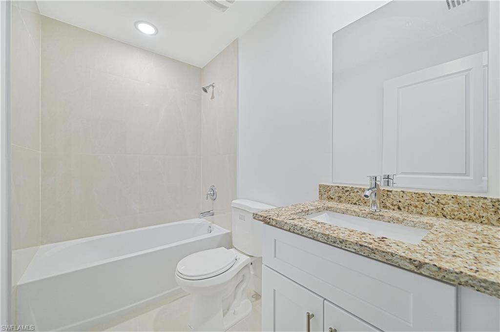 640 Lydia Street Lehigh Acres, FL 33974 - Photo 24 of 26 a bathroom with a granite countertop sink toilet and shower