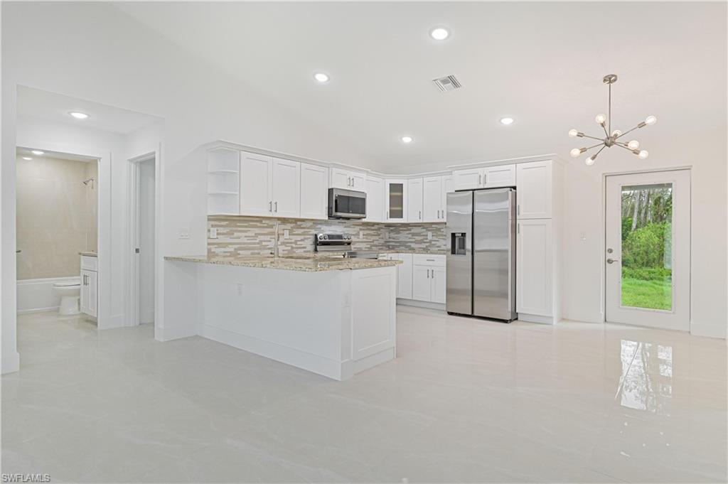 640 Lydia Street Lehigh Acres, FL 33974 - Photo 10 of 26 a kitchen with refrigerator and cabinets