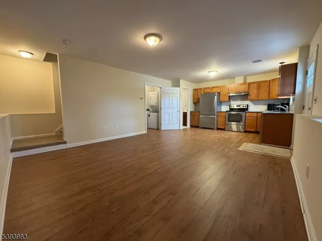 a view of a kitchen with a sink stainless steel appliances cabinets and living room view