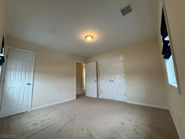 an empty room with a window and closet