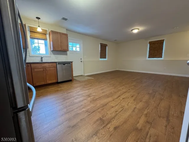 an empty room with wooden floor and window