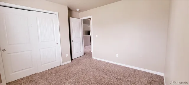an empty room with ceiling fan and window