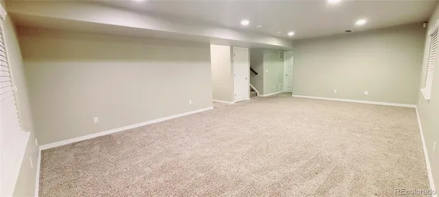 an empty room with windows and stairs