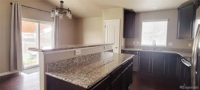 a kitchen with granite countertop a sink and a window