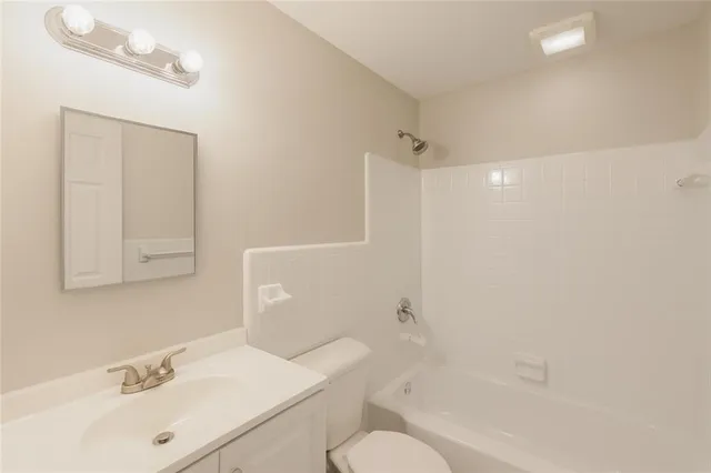 a bathroom with a sink toilet vanity and tub