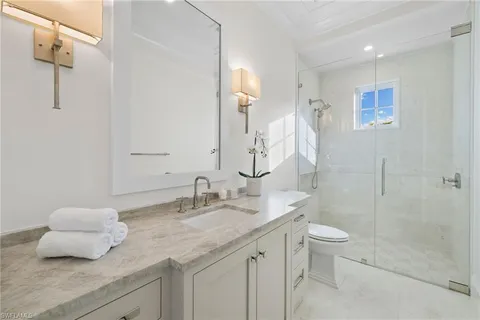 a bathroom with a granite countertop sink toilet and shower