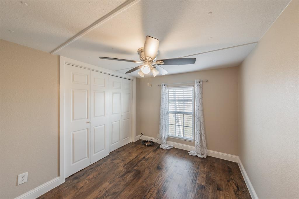 1080 Crow Lane Terrell, TX 75161 - Photo 13 of 39 Primary bedroom featuring dark wood finished floors, a ceiling fan, a closet, a textured ceiling, and a textured wall