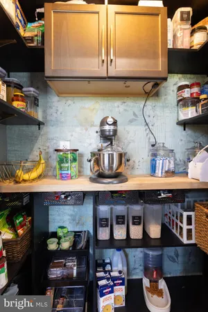 a living room with stainless steel appliances furniture and wooden floor