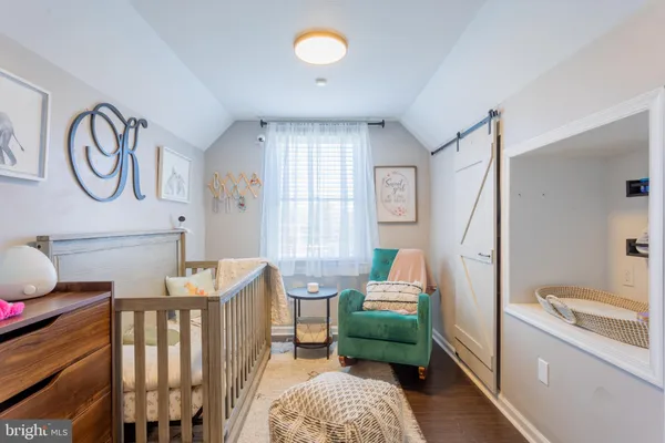 a bedroom with a bed window and a flat screen tv