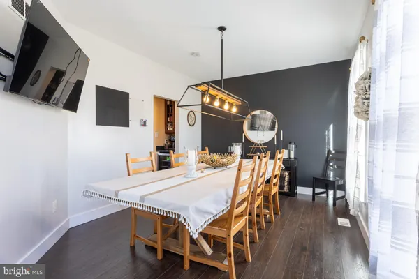 a dining room with furniture a chandelier and wooden floor
