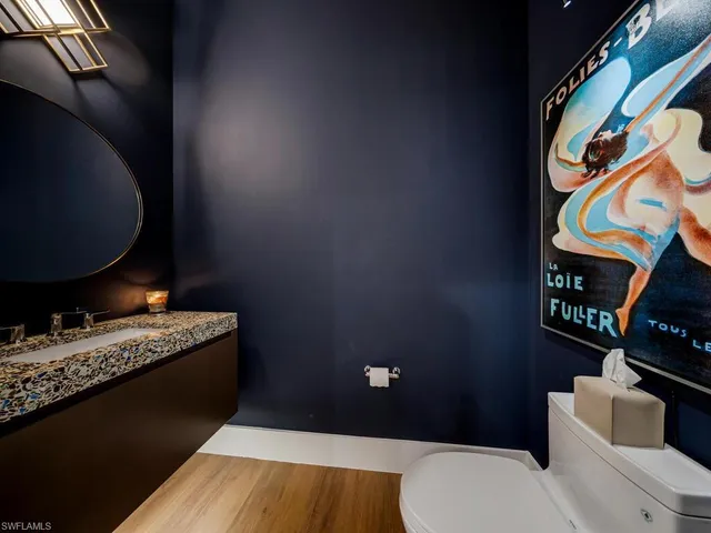 a bathroom with a granite countertop toilet and a sink