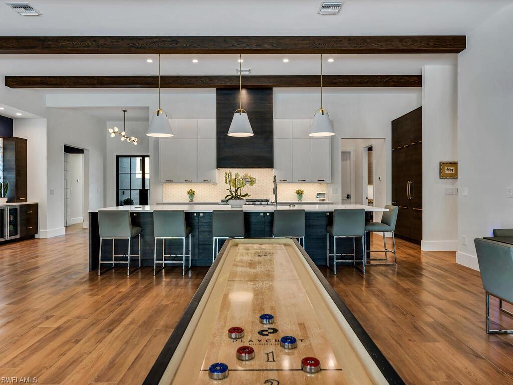 1251 Creech Road Naples, FL 34103 - Photo 11 of 42 a dining hall with stainless steel appliances kitchen island a table and chairs in it