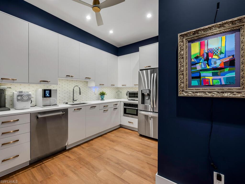1251 Creech Road Naples, FL 34103 - Photo 12 of 42 a kitchen with stainless steel appliances granite countertop a refrigerator sink and stove