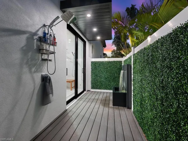 a porch with wooden floor stairs and a potted plant