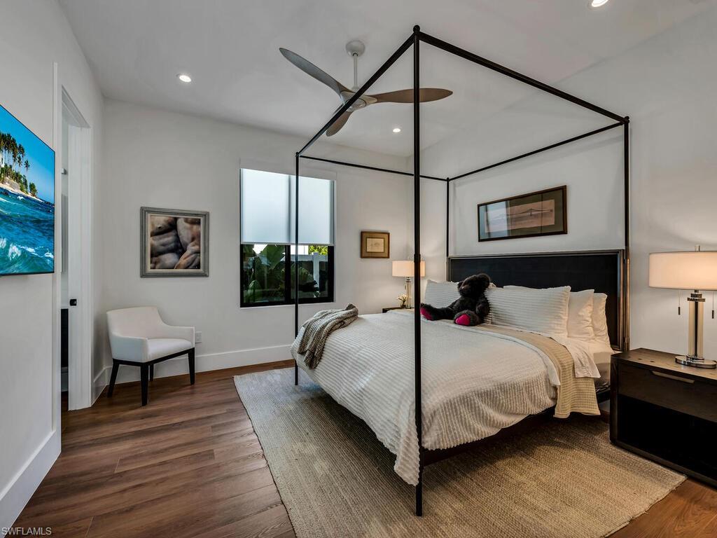 1251 Creech Road Naples, FL 34103 - Photo 25 of 42 a bedroom with a bed and wooden floor
