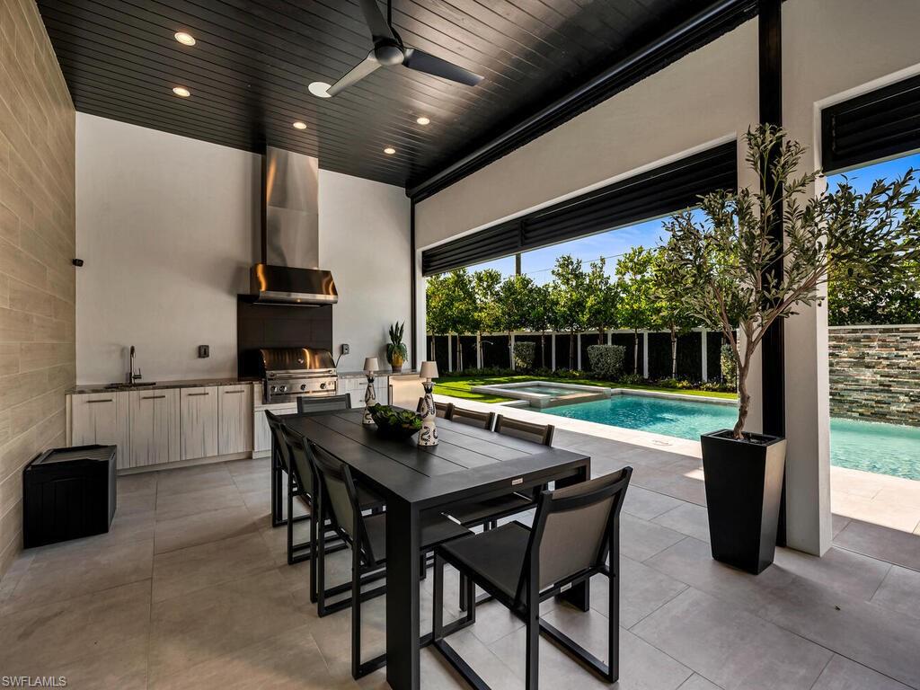 1251 Creech Road Naples, FL 34103 - Photo 34 of 42 a view of a patio with a dining table and chairs with a small yard