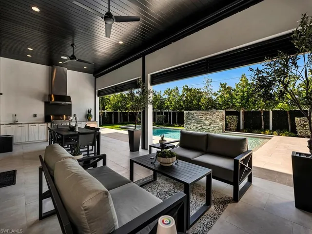 a view of a house with pool and chairs in patio