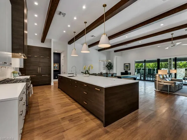 a large kitchen with stainless steel appliances granite countertop a large counter top a stove and a sink