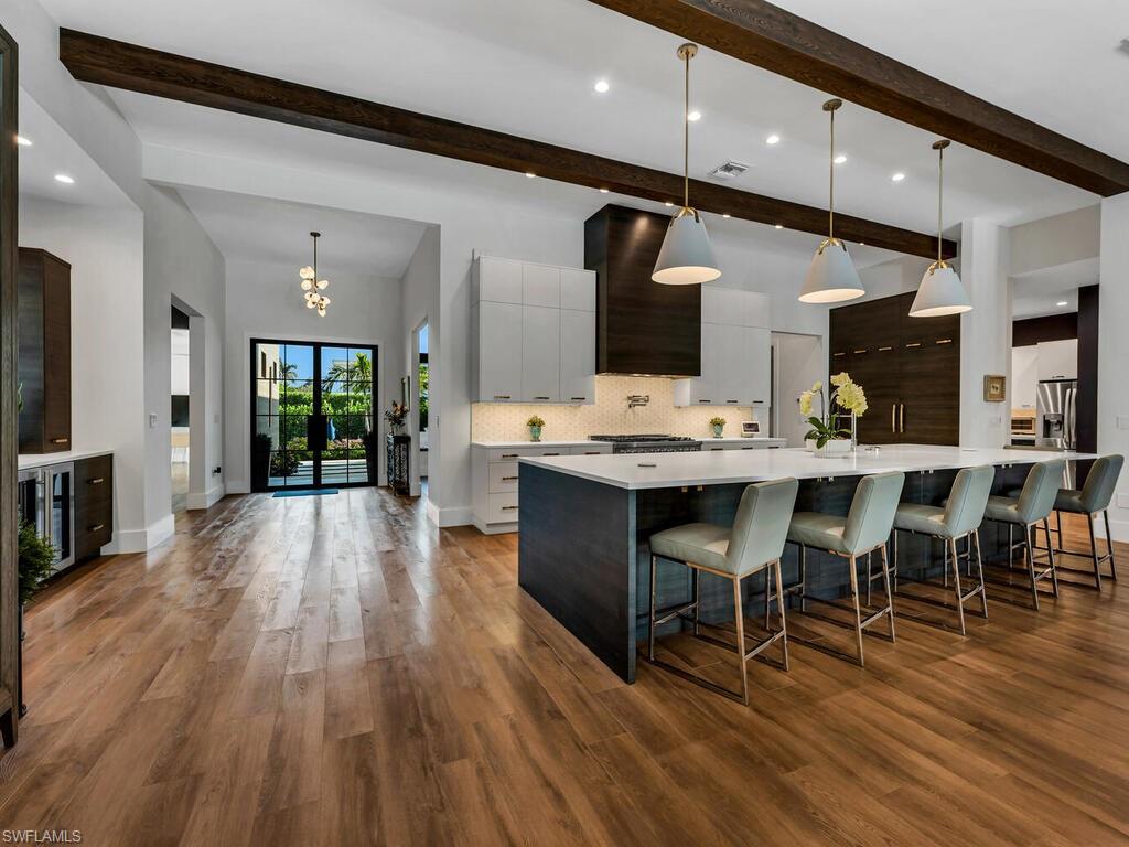 1251 Creech Road Naples, FL 34103 - Photo 6 of 42 a open kitchen with stainless steel appliances kitchen island granite countertop a table chairs and a sink