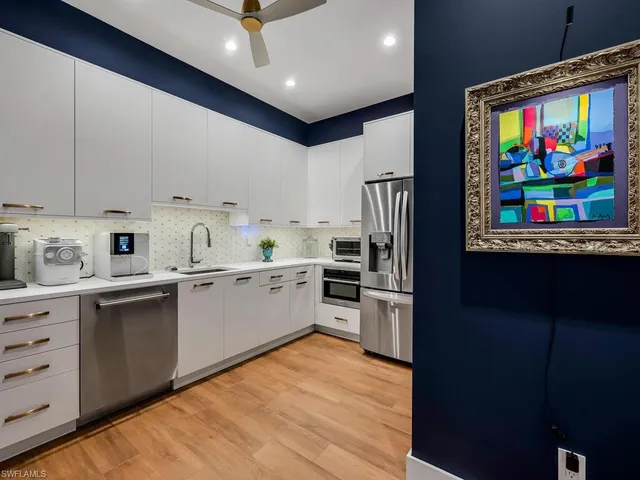 a kitchen with stainless steel appliances granite countertop a refrigerator sink and stove