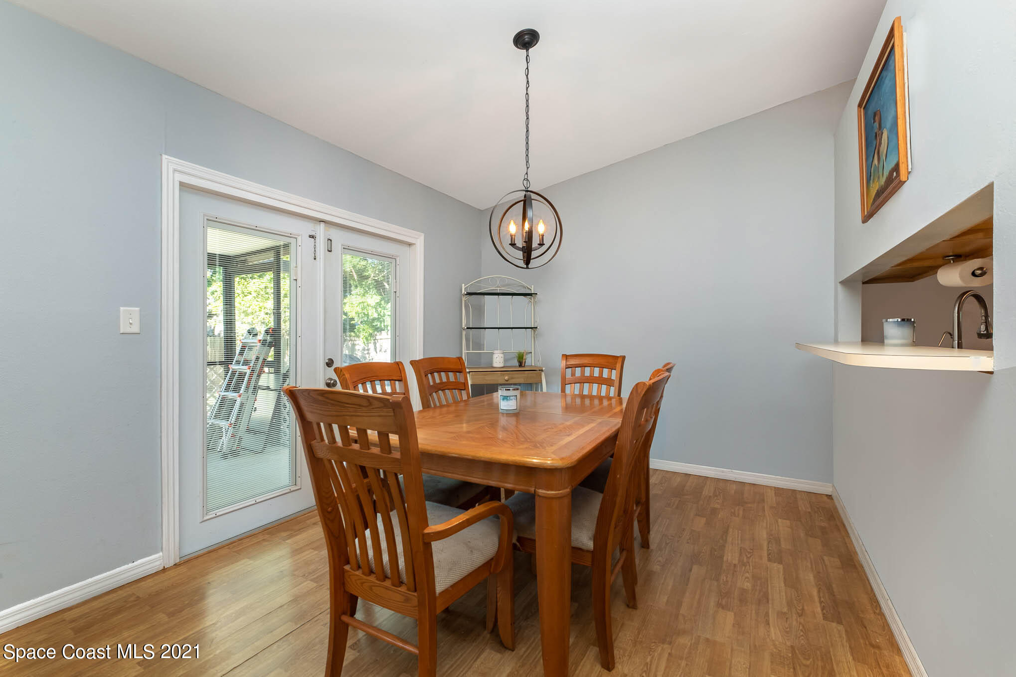 3750 Ranger Street Titusville, FL 32796 - Photo 9 of 22 a dining room with furniture a rug a potted plant and wooden floor