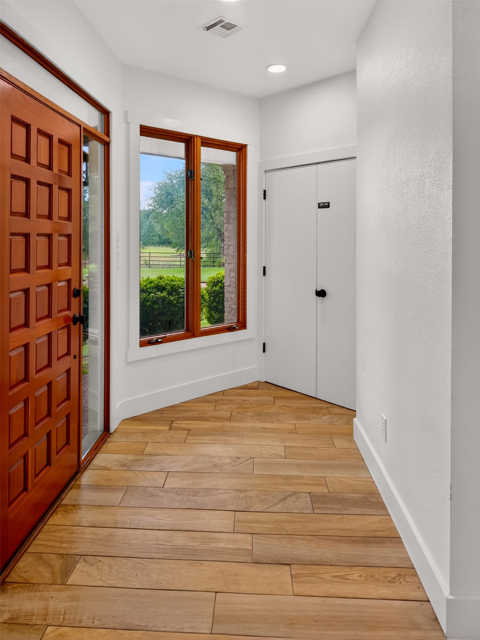 6106 Southeast Fm Ranch Buckholts, TX 76518 - Photo 12 of 38 The entry features a paneled wooden front door, wood-framed windows, and light wood plank flooring