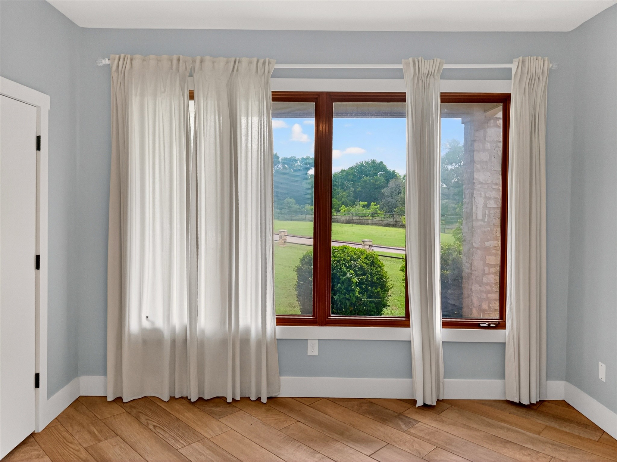 6106 Southeast Fm Ranch Buckholts, TX 76518 - Photo 21 of 38 This room features wood plank flooring and a wall of windows, providing natural light and views of a verdant lawn and mature trees