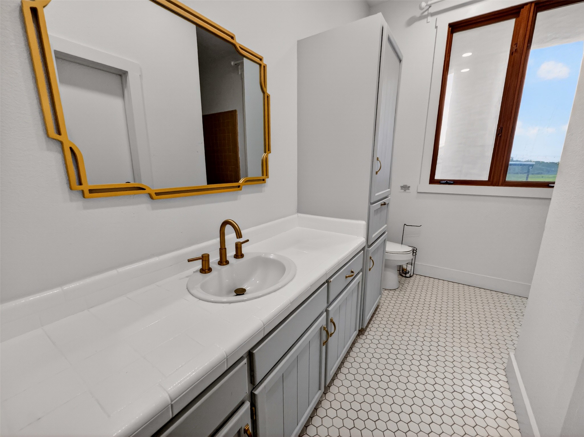 6106 Southeast Fm Ranch Buckholts, TX 76518 - Photo 23 of 38 This bathroom features a vanity with a white countertop and white sink, complemented by a gold-framed mirror