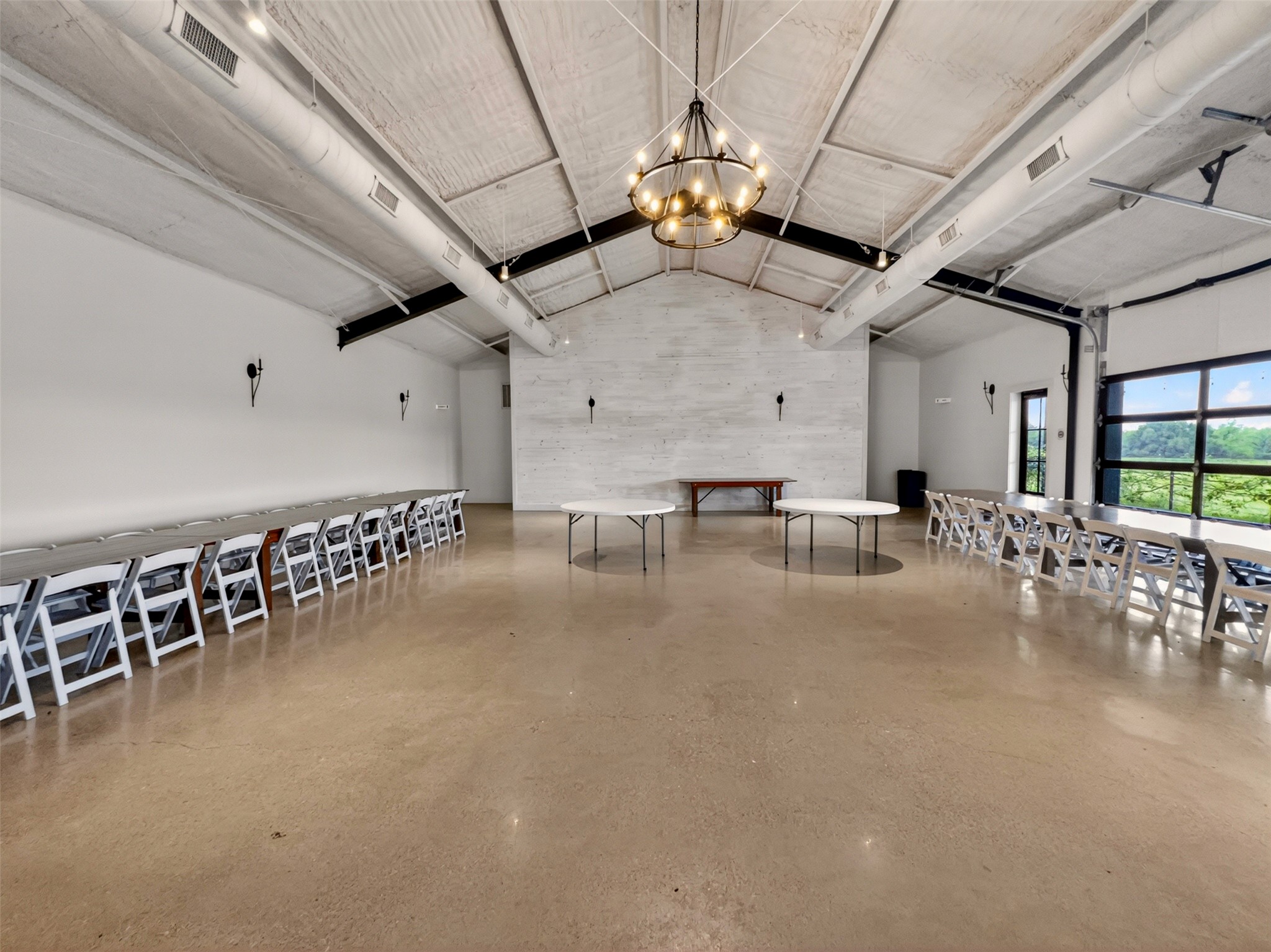 6106 Southeast Fm Ranch Buckholts, TX 76518 - Photo 29 of 38 This expansive room features polished concrete flooring, a vaulted ceiling with exposed beams and ductwork, and a large central chandelier