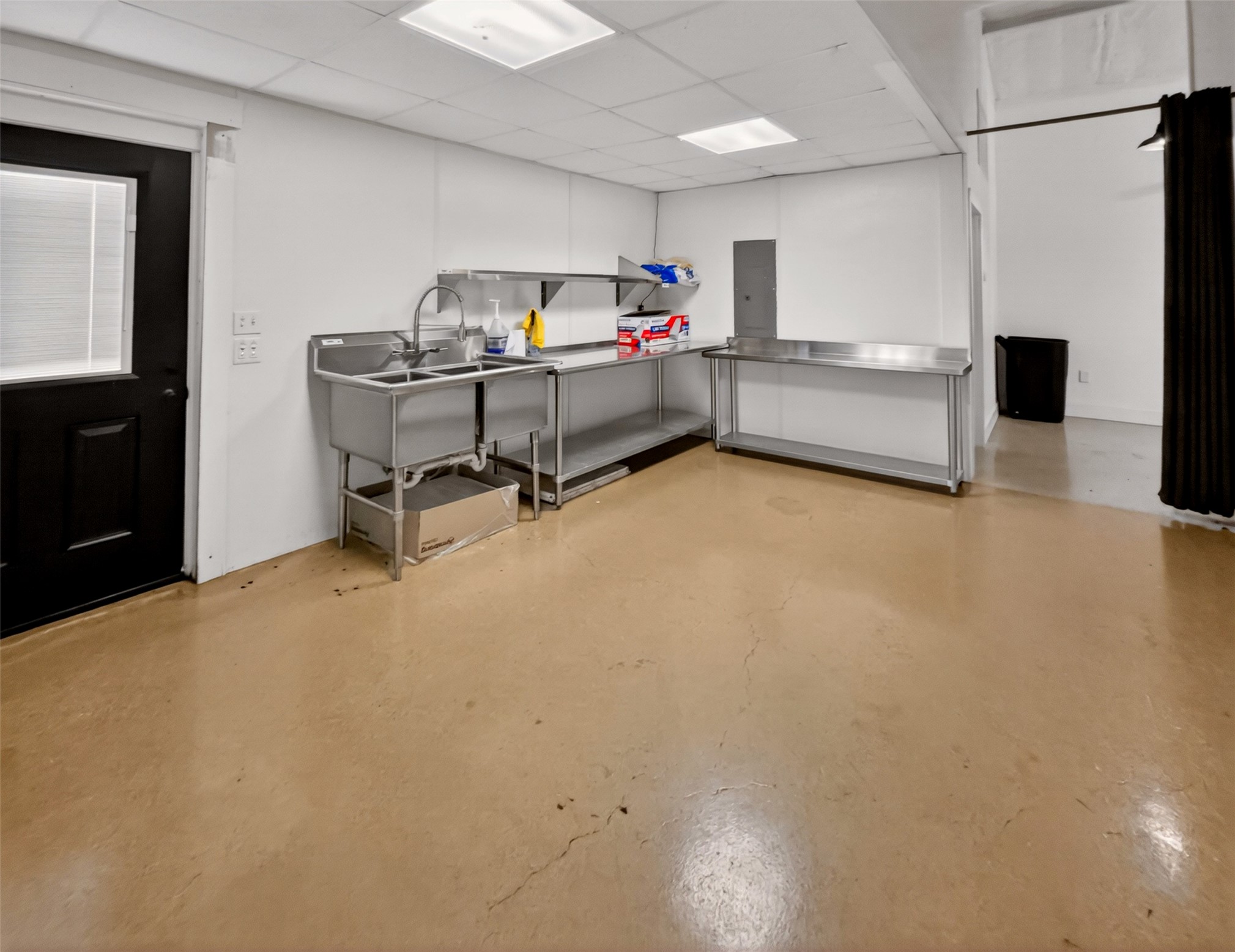 6106 Southeast Fm Ranch Buckholts, TX 76518 - Photo 31 of 38 Spacious room featuring light-colored flooring, white walls, and a black door with a window