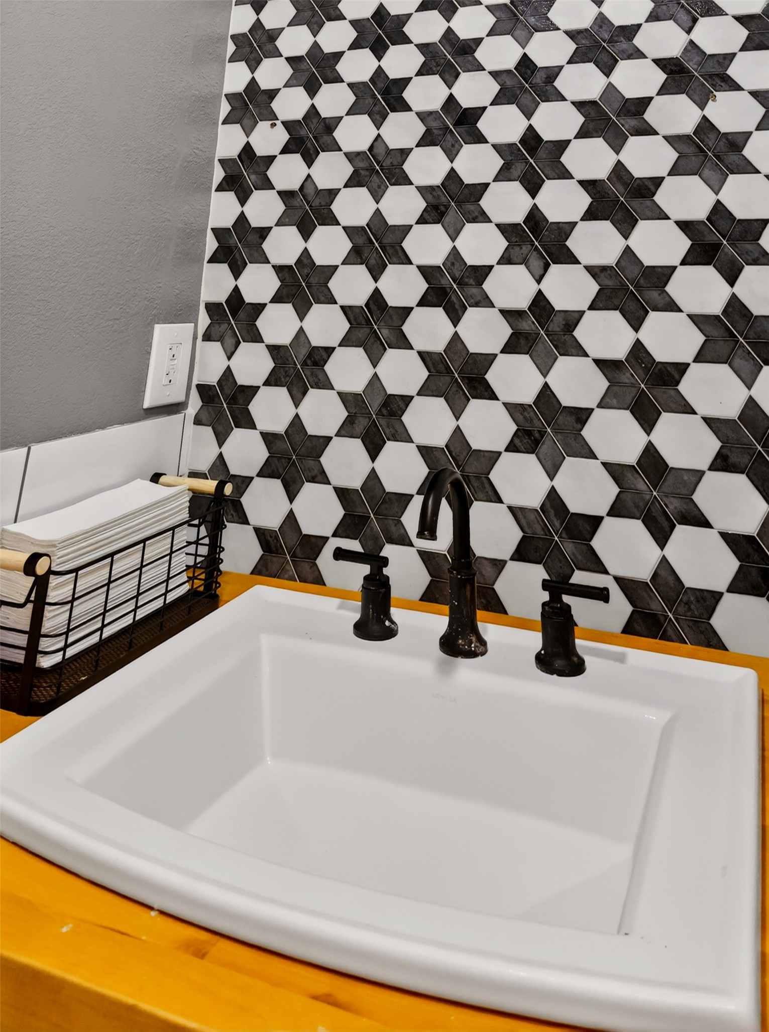 6106 Southeast Fm Ranch Buckholts, TX 76518 - Photo 33 of 38 Bathroom vanity featuring a white sink, dark-toned faucet, and a decorative tile backsplash with a geometric pattern