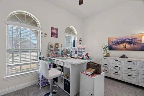 a view of a workspace with furniture and a window